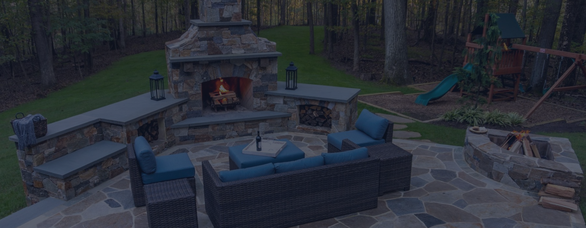 Backyard stone patio with fireplace